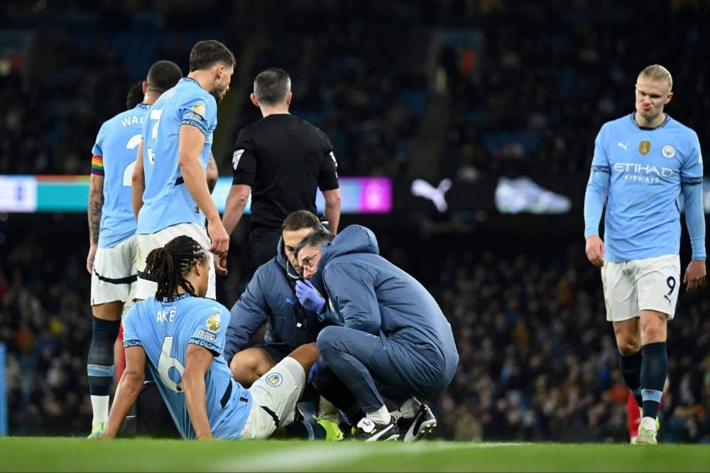 Manchester City-spillere samlet rundt skadde Nathan Aké, med Erling Haaland til høyre. Arkivfoto fra 2024.